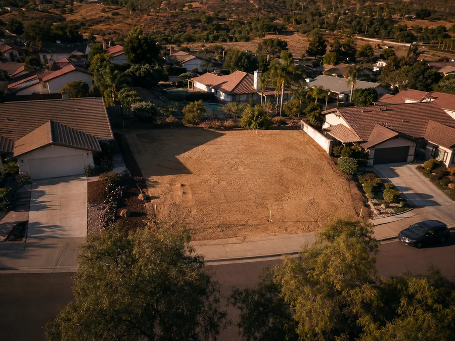 Empty lot from the air, between finished homes